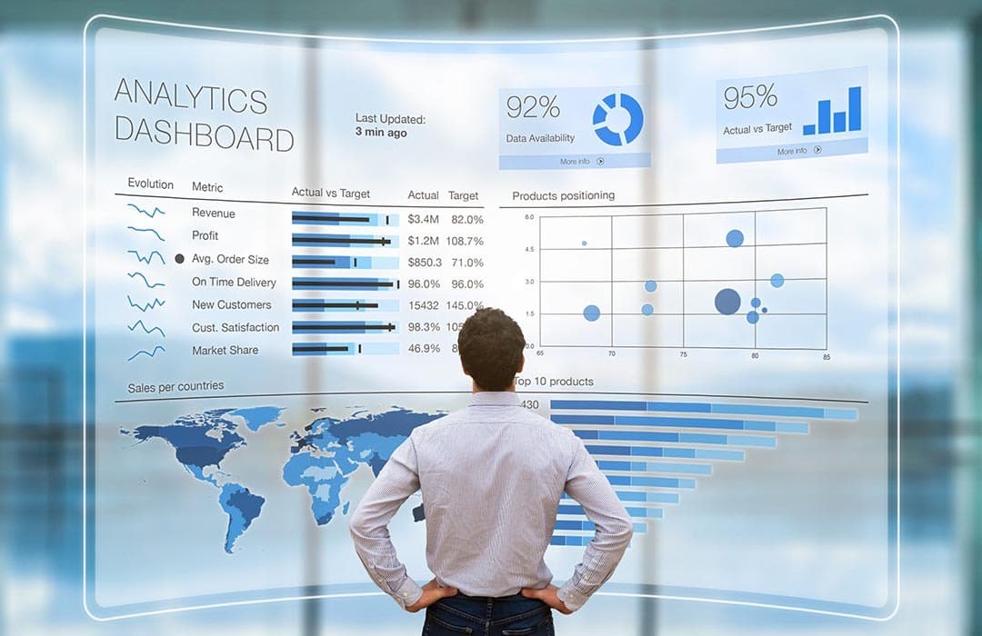 Spreadsheet papers connected to checked charts on a laptop and an open reporting notebook.